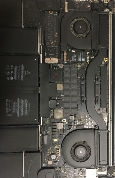 A MacBook logic board open for repair on the bench